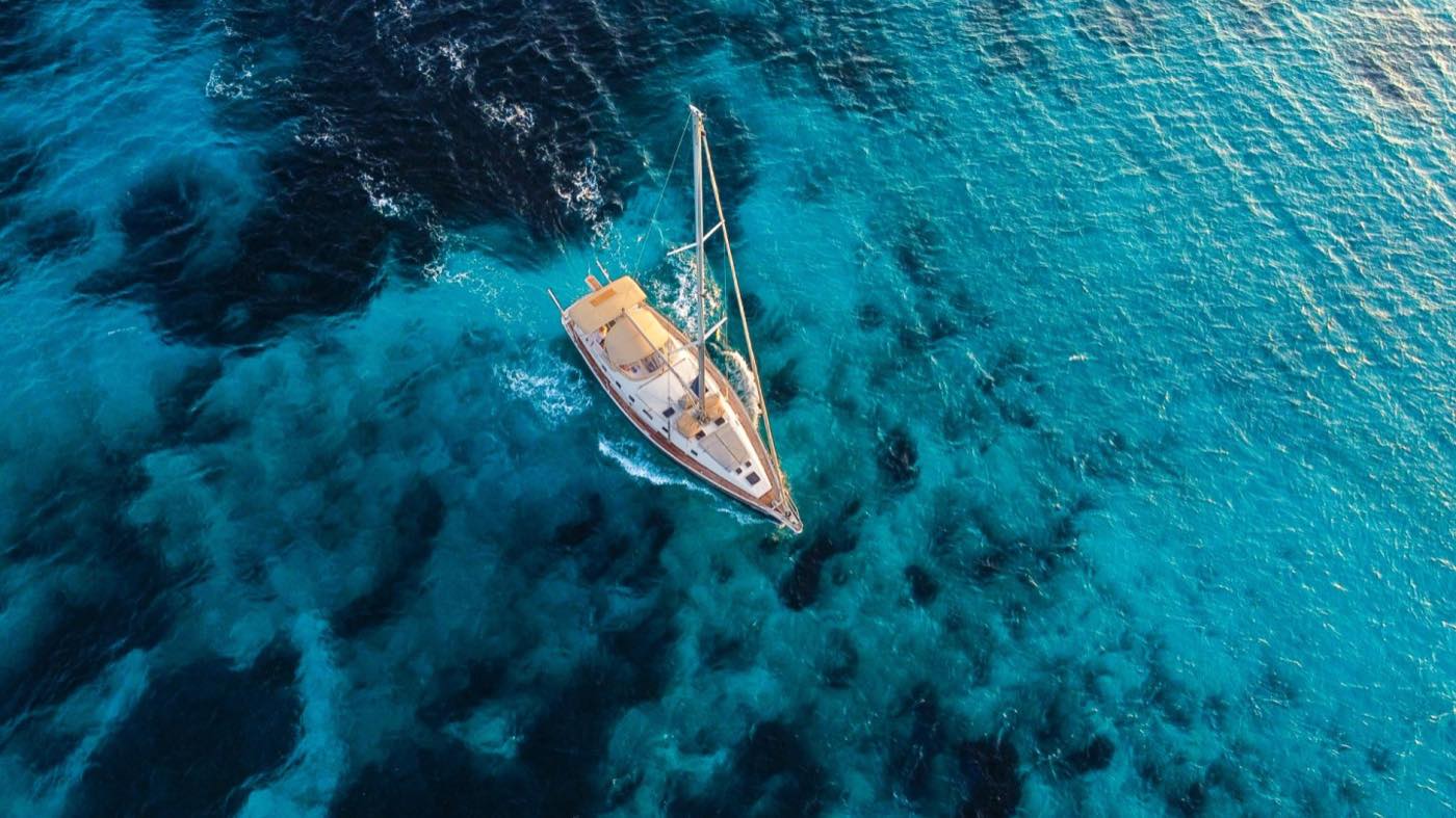 Voilier en navigation vu du ciel sur une eau profonde