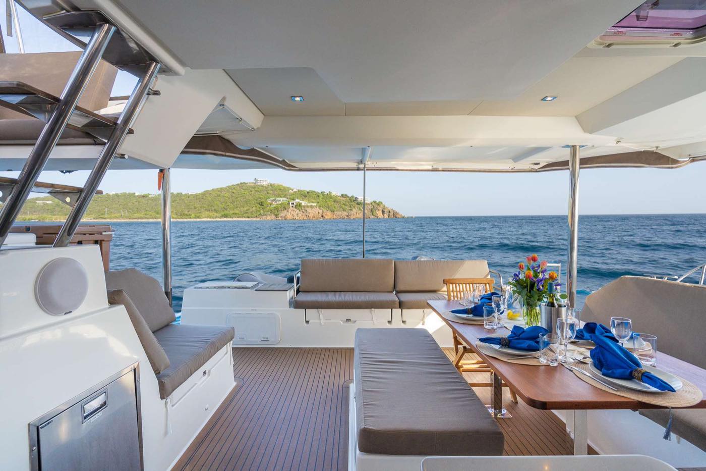 Cockpit d’un catamaran préparé avant l’arrivée du propriétaire, table dressée et coussins en place